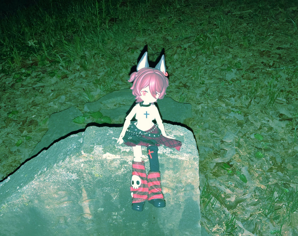 Elizabeth sitting on a small grave stone. The camera is far away from her and there is a blue filter applied.