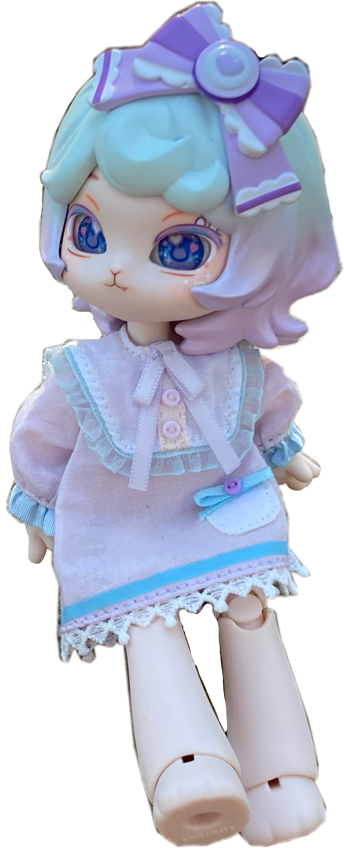 Taro is a rabbit-like doll who has short hair thats in a graident from light blue to light purple. She wears a big, purple bow and a light-purple nightgown with light blue accents.