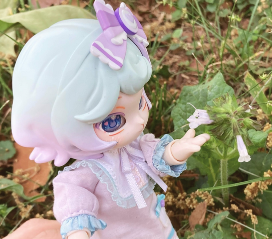 Taro with her paw under a bell-shaped white flower.